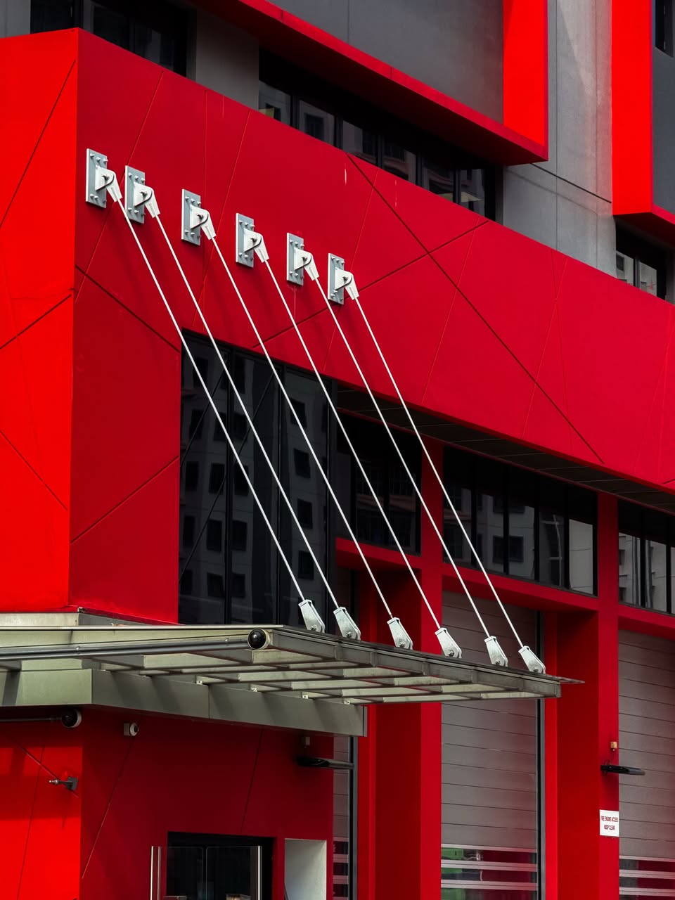 Architectural elements with red cladding and stylised R emblems