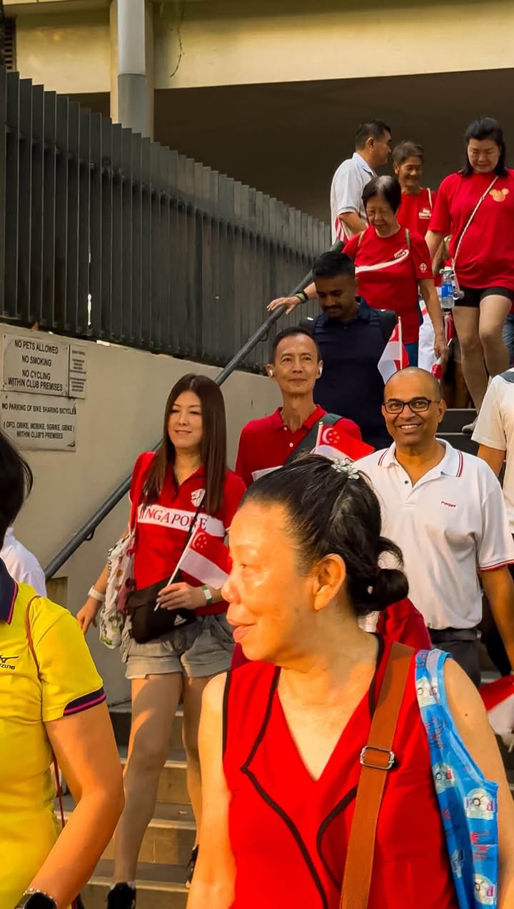 Participants in Singapore-themed red shirts ascending stairs