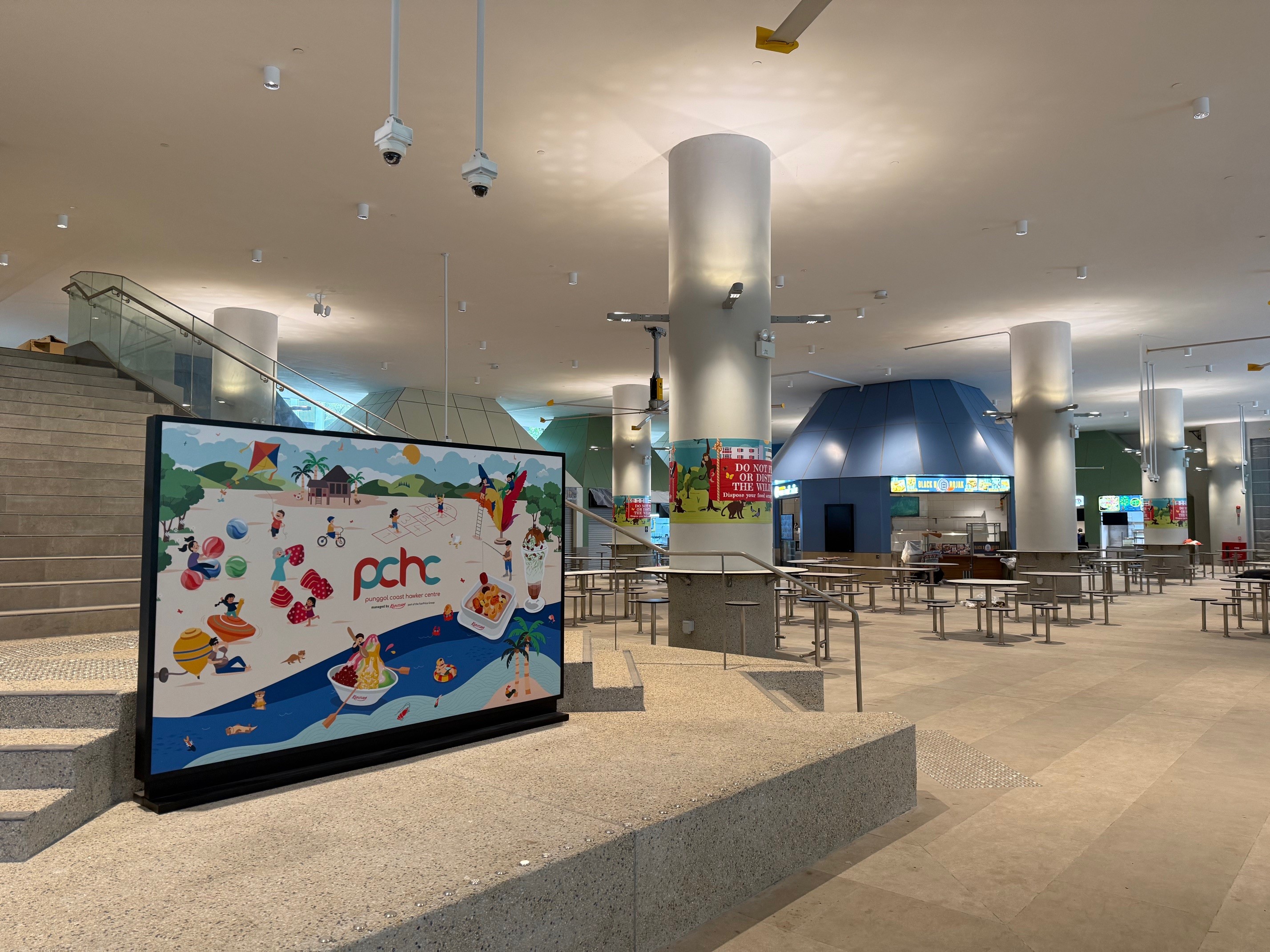 Punggol Coast Hawker Centre hall with the PCHC sign during a quieter service, 84 Punggol Way