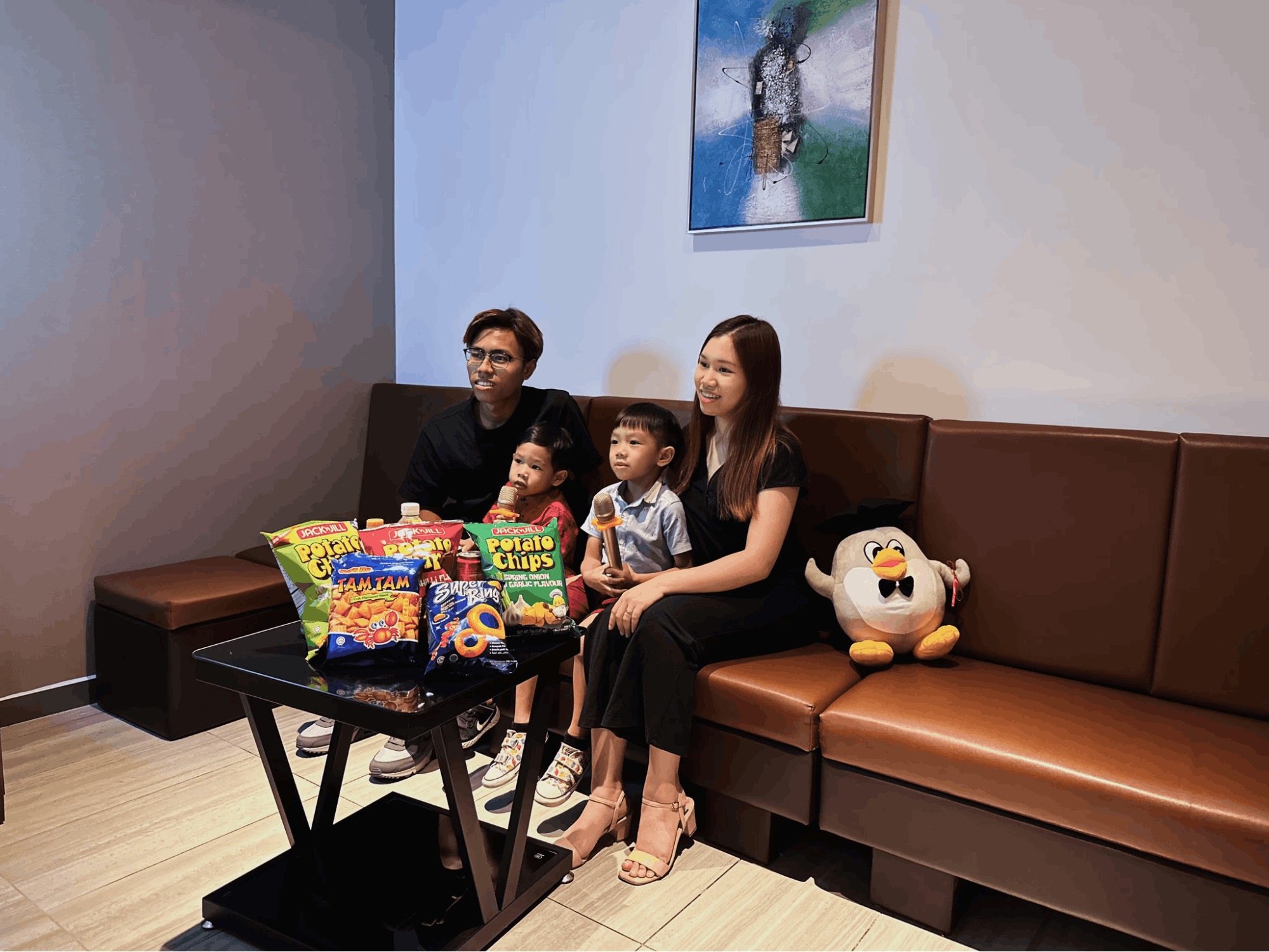 Family singing at Teo Heng with snacks on the table at Punggol Coast Mall