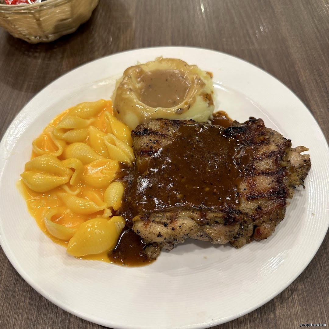 A plate of grilled chicken, mac and cheese, and mashed potatoes.
