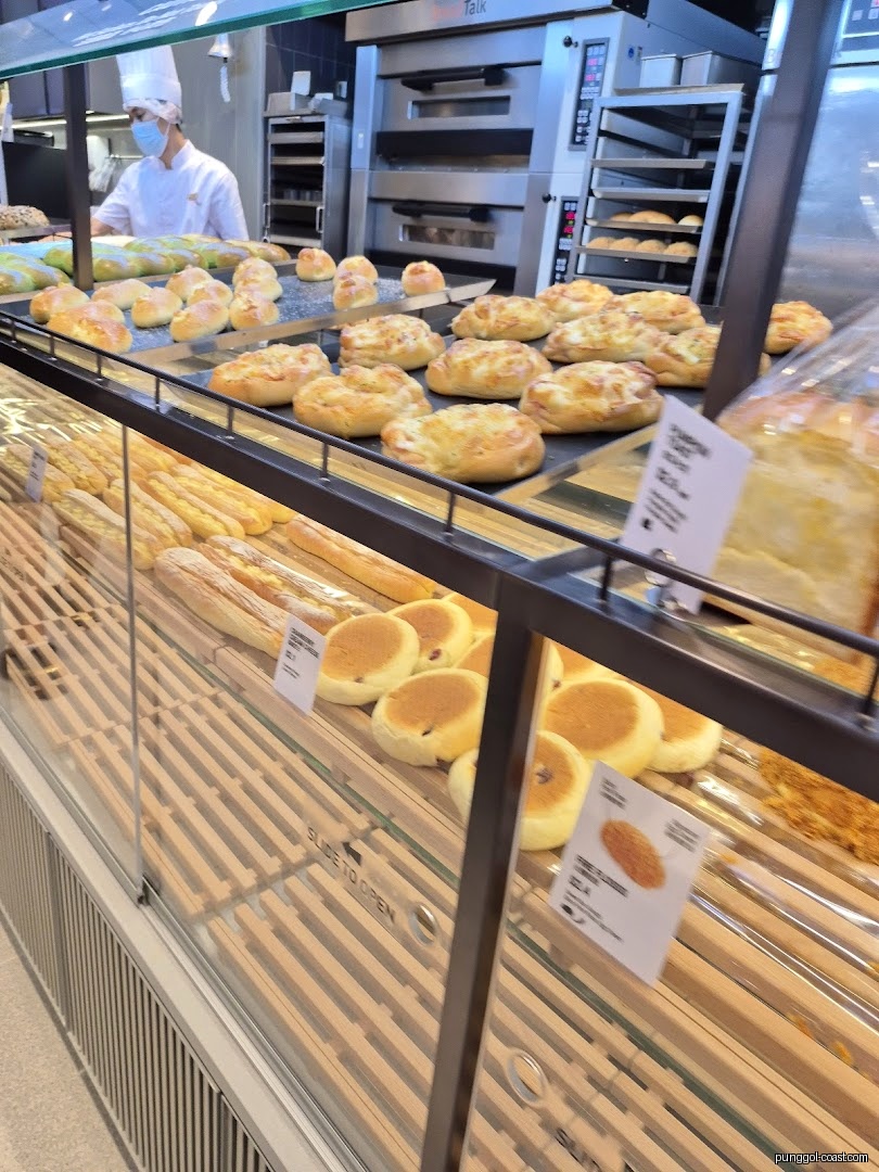 Interior of a bakery showing fresh bread displays and ovens.