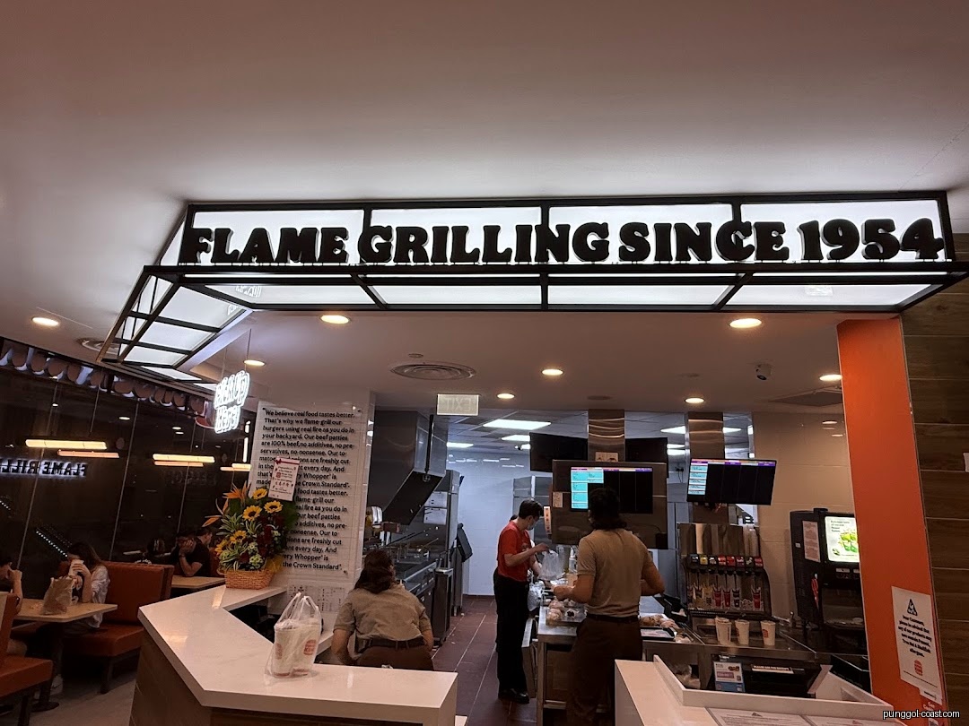 Interior view of Burger King with staff, customers, and counter area.