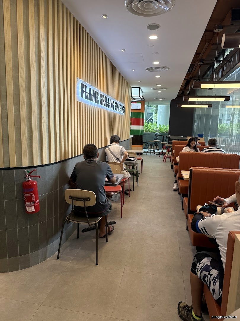 Diners seated in a Burger King interior with flame grilling sign.
