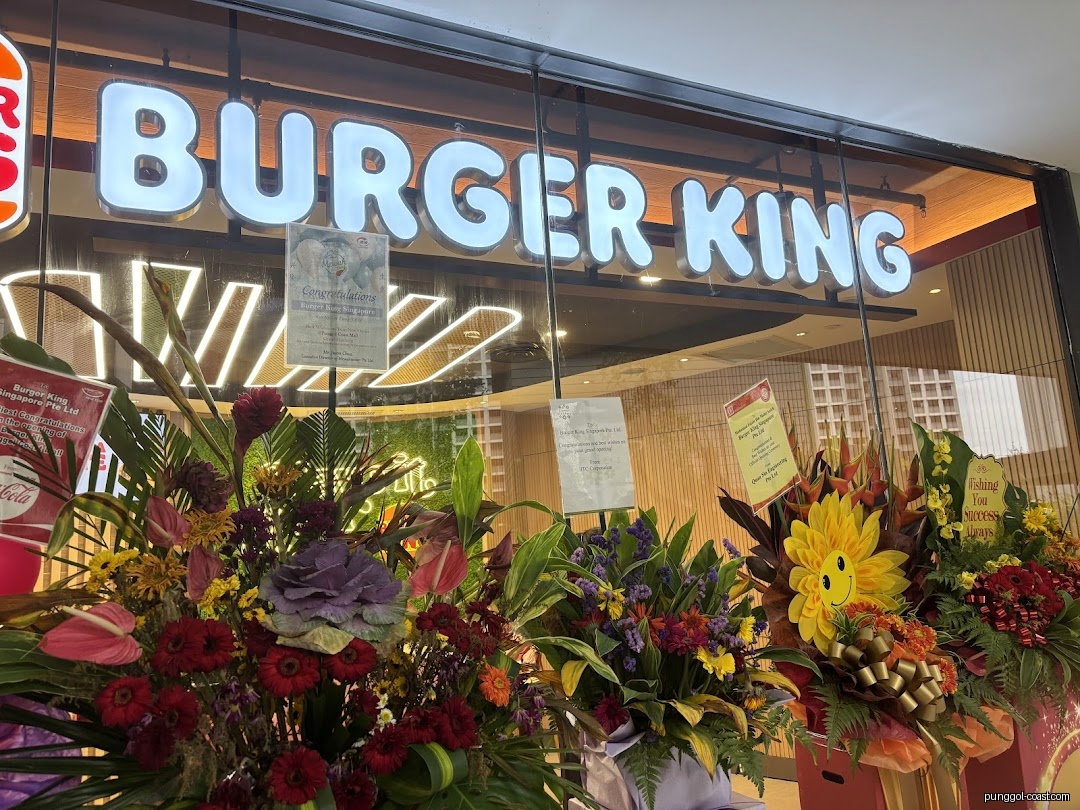 Burger King shop front with large floral arrangements for an opening.