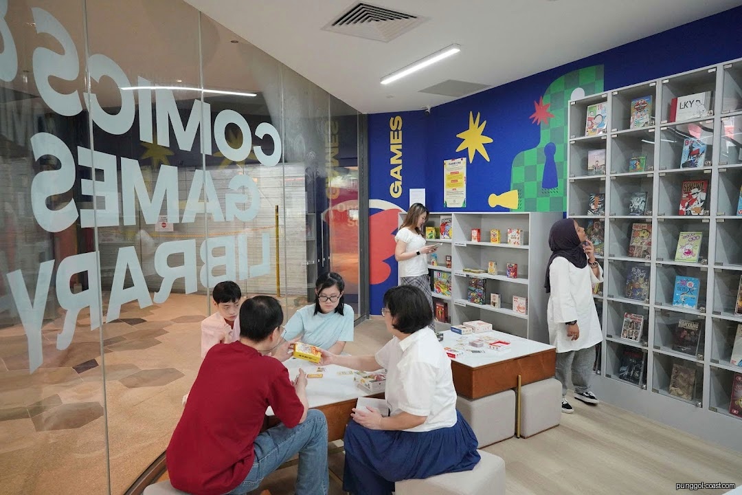 Customers playing games and browsing comics inside the library.
