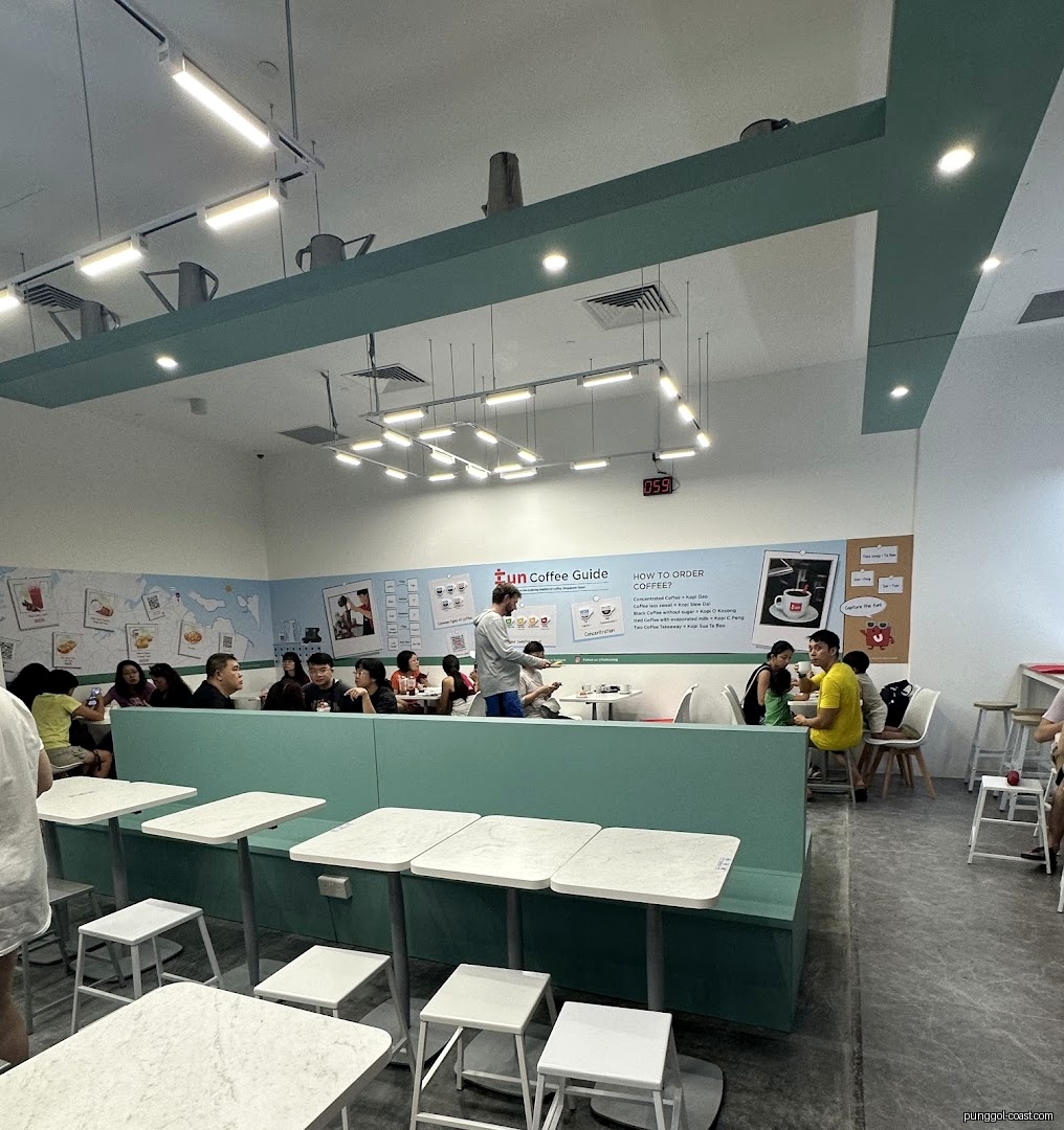 Interior view of a cafe with customers seated at tables and wall decor.