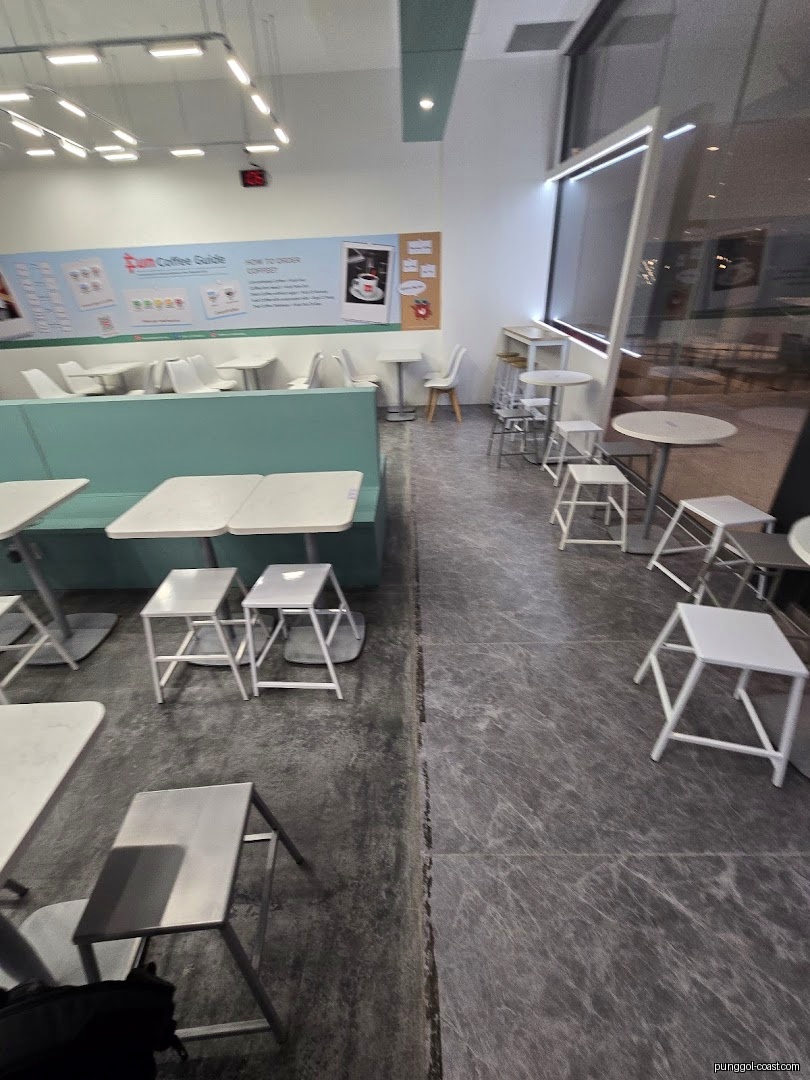 Interior view of a cafe with tables, chairs, and a coffee guide poster.