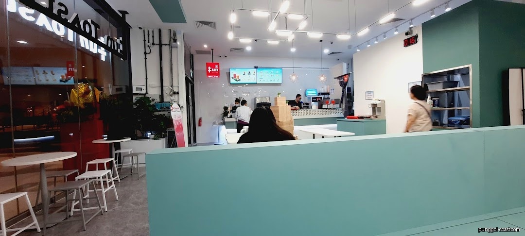 Interior view of a modern toast shop with customers and staff.