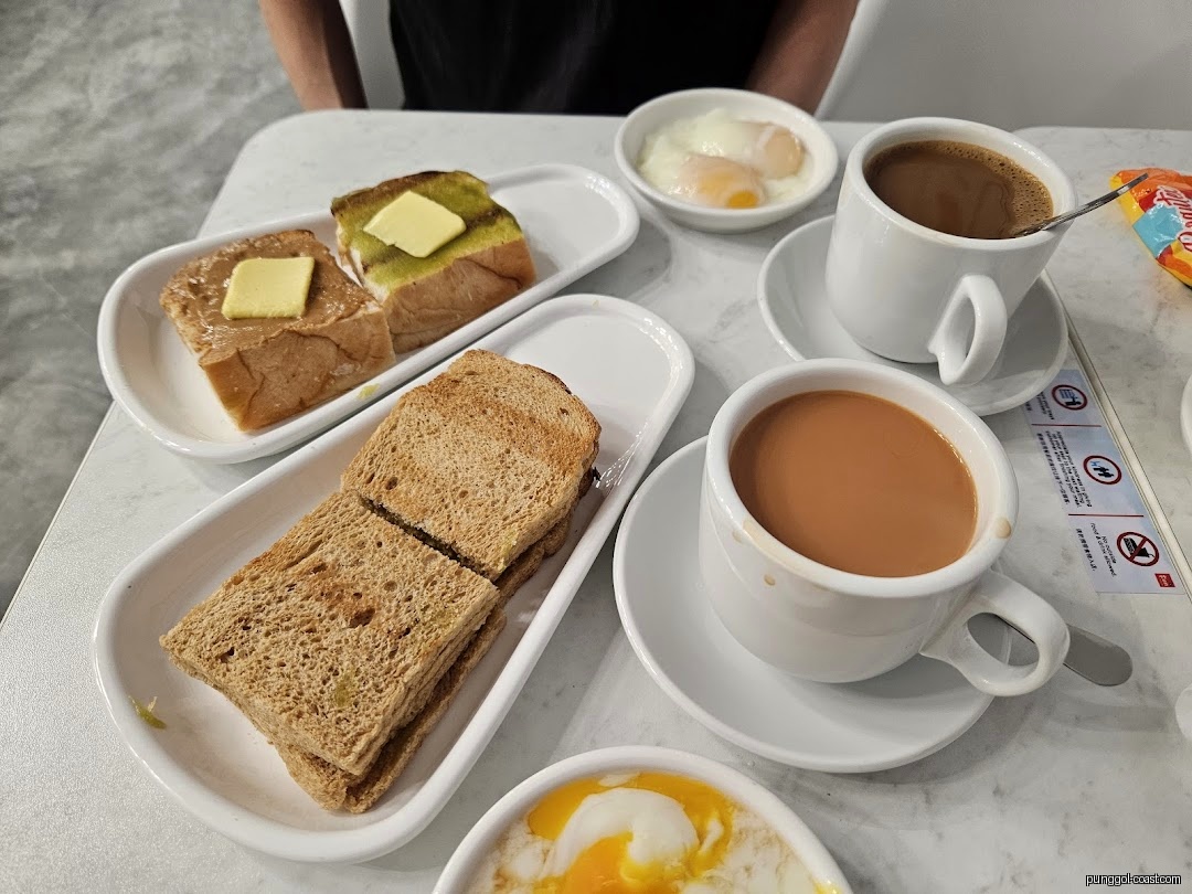 A table with toast, soft-boiled eggs, coffee, and tea at Fun Toast.