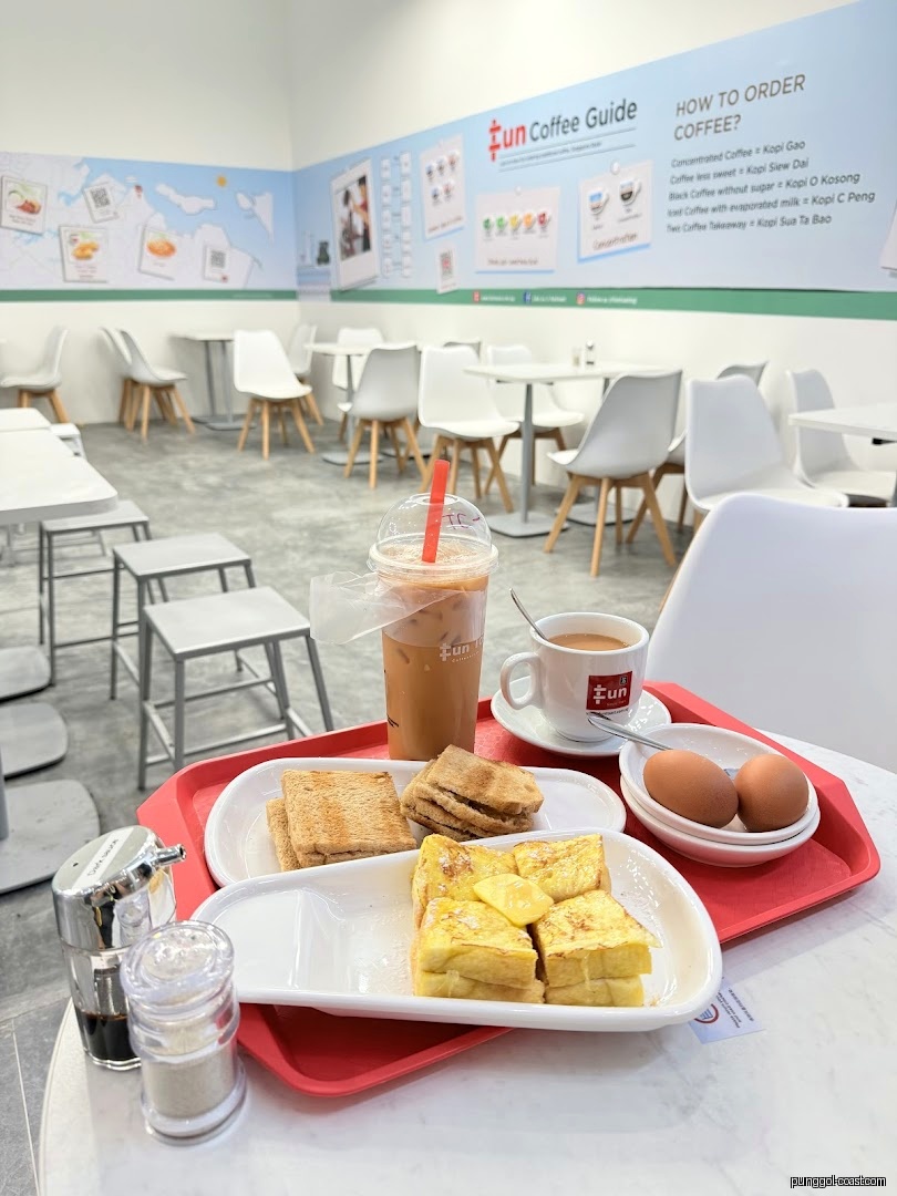 Cafe interior showing a breakfast tray with toast, eggs, and coffee.