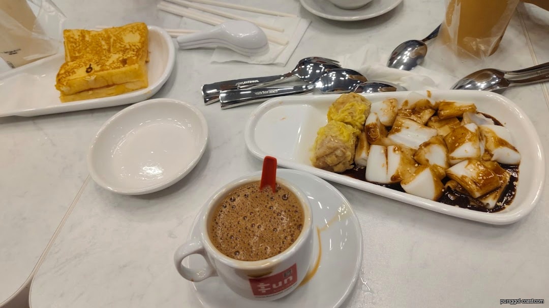 Table with coffee, toast, cheong fun, and siew mai.
