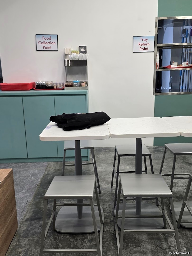 Shop interior with tables, stools, and food collection/tray return points.