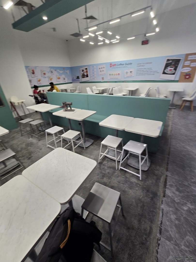 Interior view of a cafe with tables, chairs, and some customers.