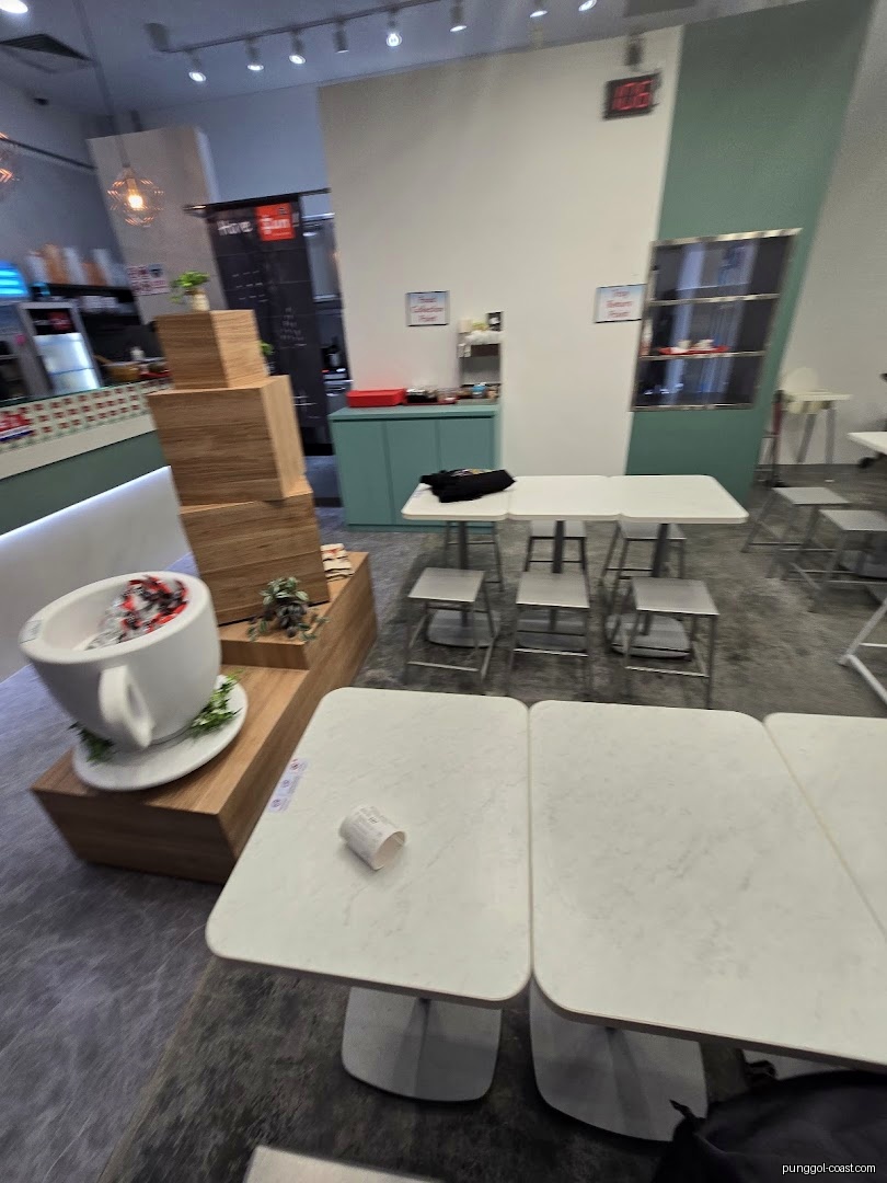 Interior view of a cafe with tables, chairs, and a counter area.