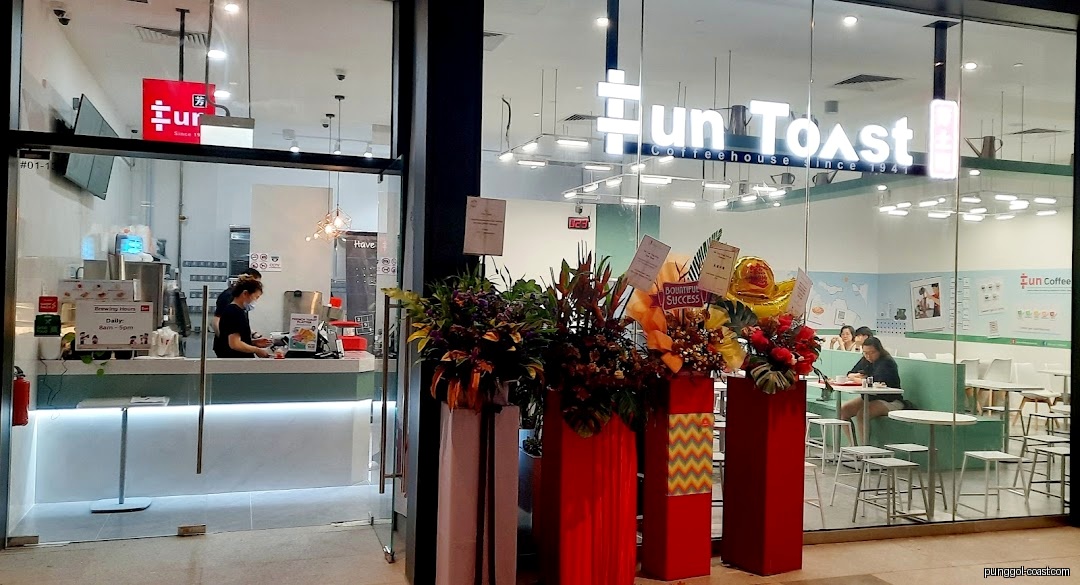 Exterior view of Fun Toast coffeehouse with glass front and floral arrangements.