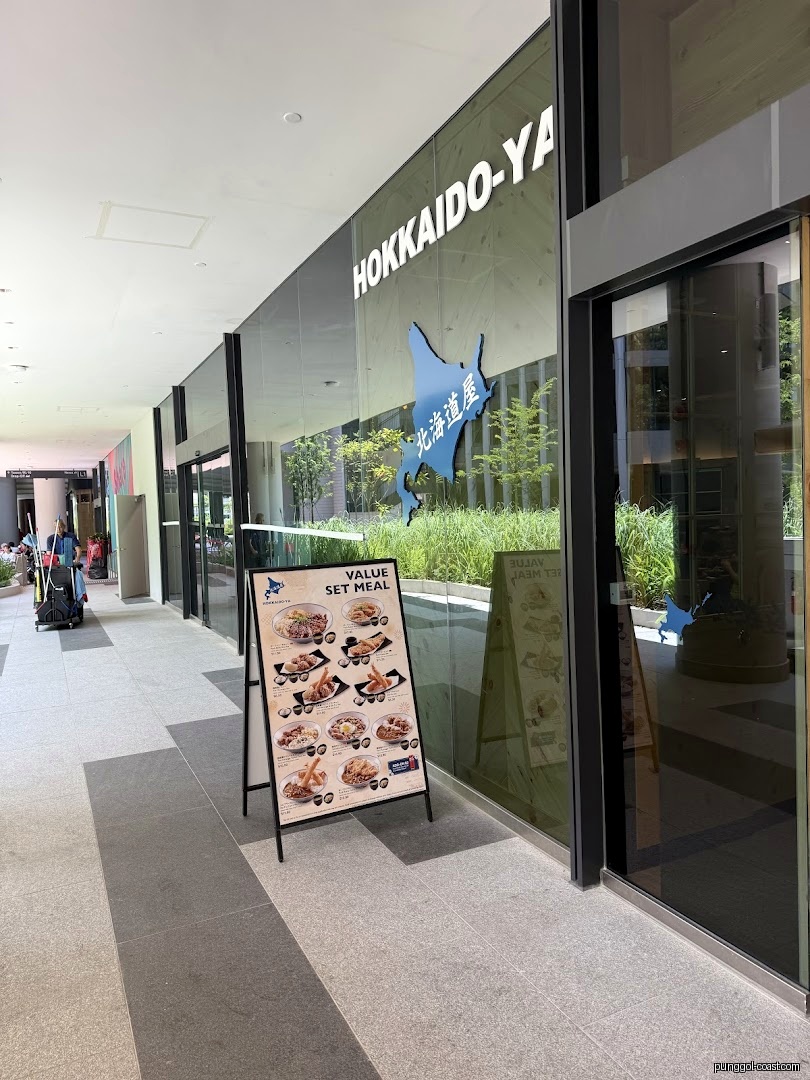 Exterior view of Hokkaido-ya shop with glass facade and outdoor menu board.