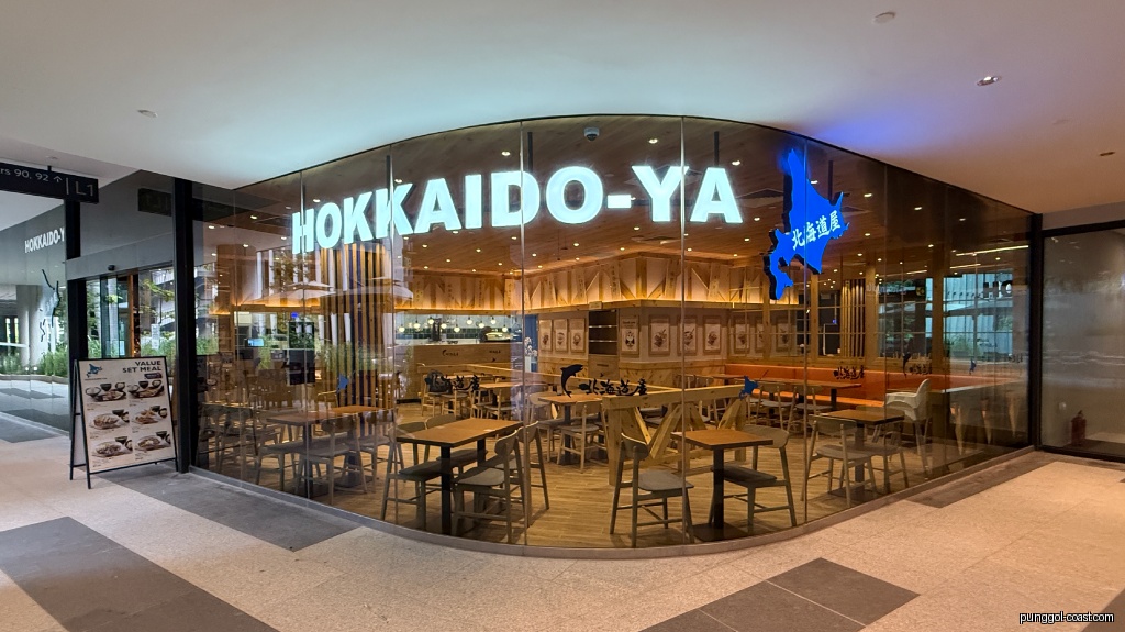 Hokkaido-ya shop exterior with glass facade, showing interior and outdoor menu.