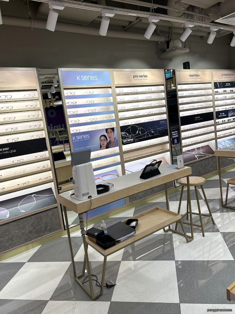 Interior view of an eyeglasses shop with display walls and a counter.