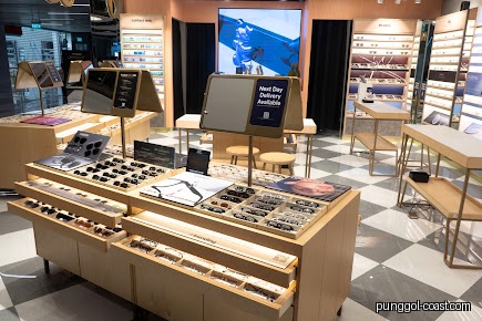 Interior view of a Lenskart store with display tables of glasses and contact lenses.