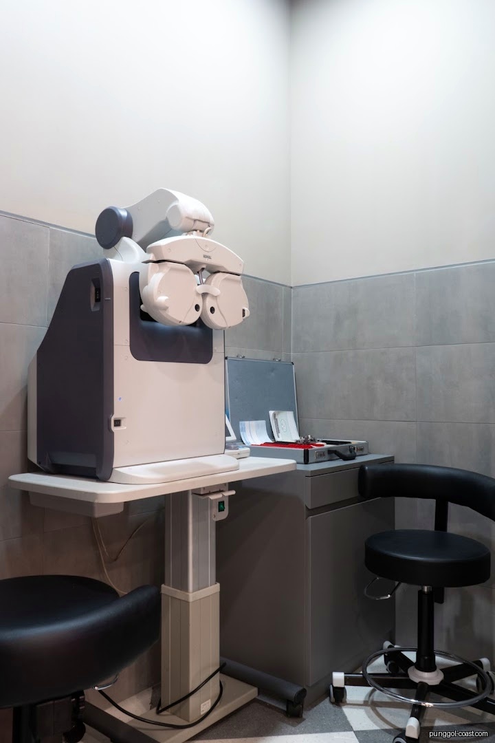 Eye examination room with testing equipment and chairs.