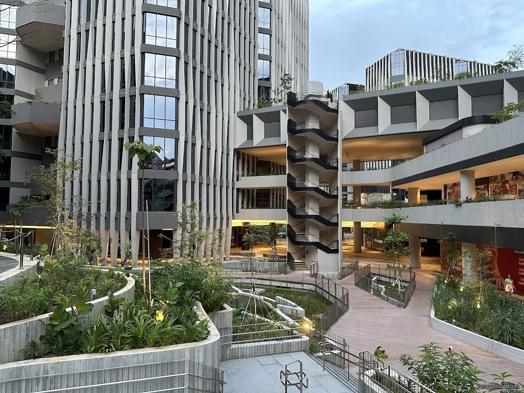 Modern commercial complex with walkways, green spaces, and multiple buildings.