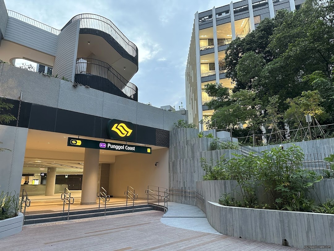 Modern entrance to Punggol Coast MRT station with surrounding architecture and greenery.
