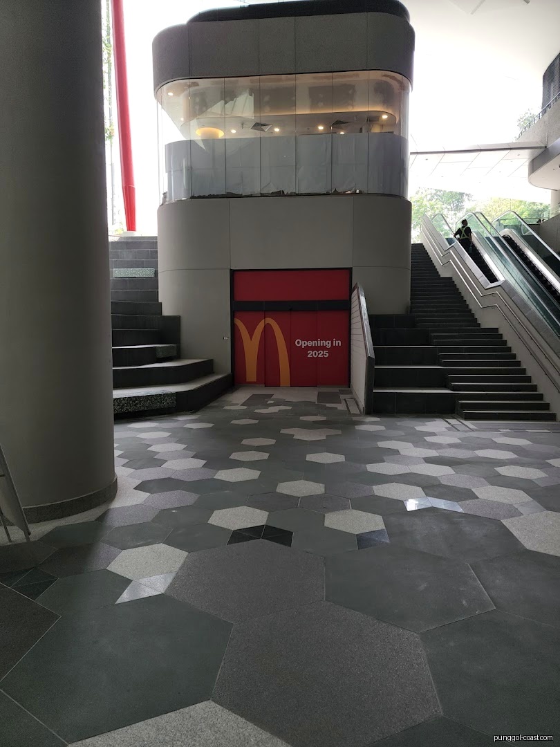 McDonald's entrance with 'Opening in 2025' sign, stairs, and escalators.