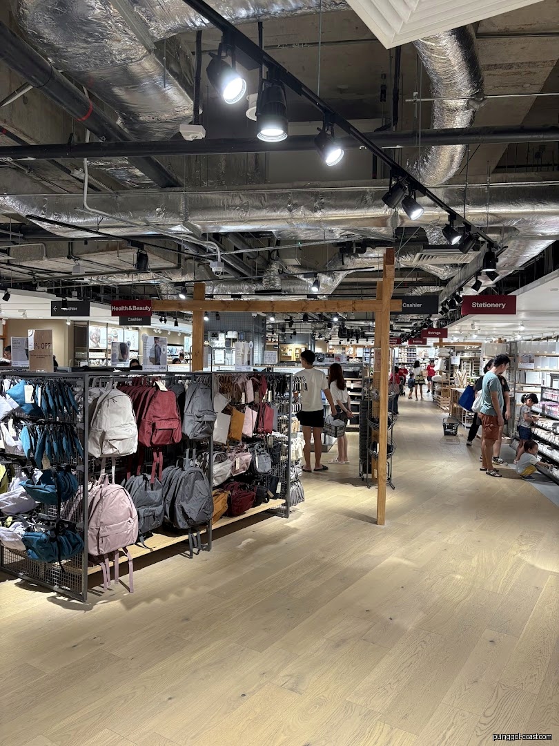 Interior view of a retail shop with bags on display and shoppers.