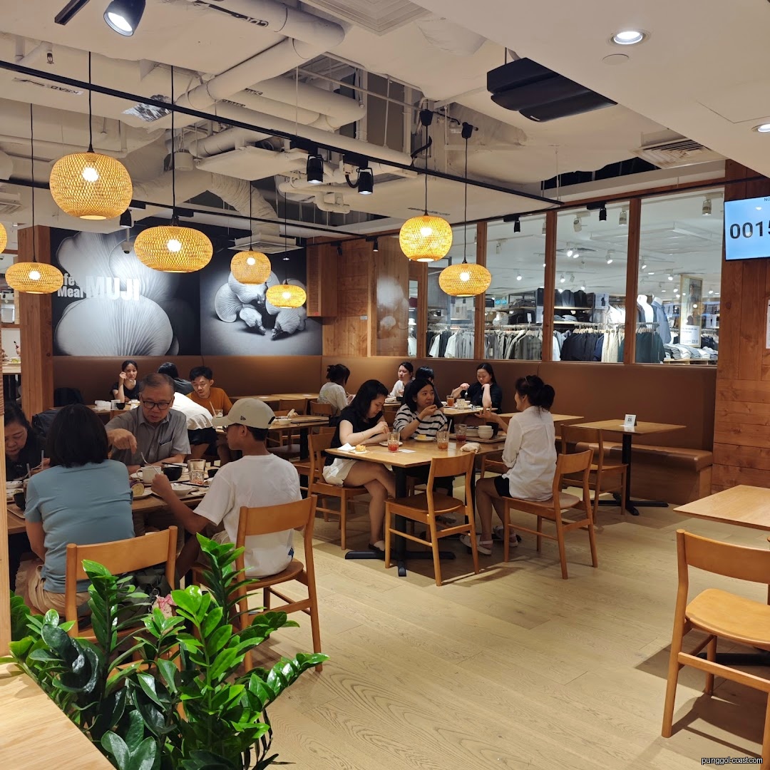People dining in a cafe area with a view into a clothing retail section.