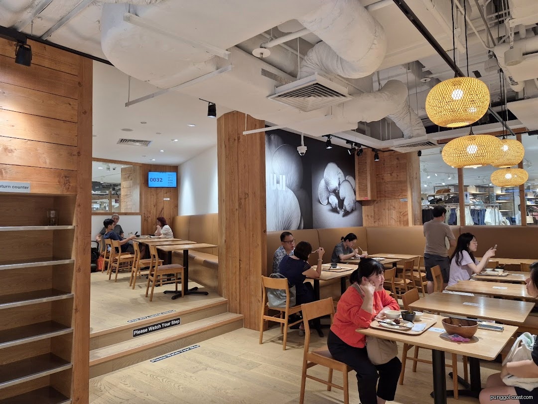 Customers dining in a modern cafe with wooden furnishings and a large mural.