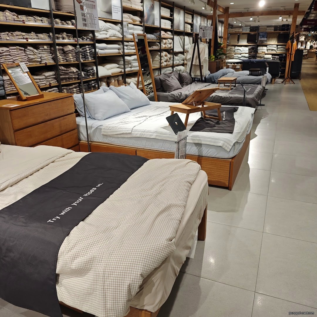 Retail store interior showing multiple beds and bedding on display.