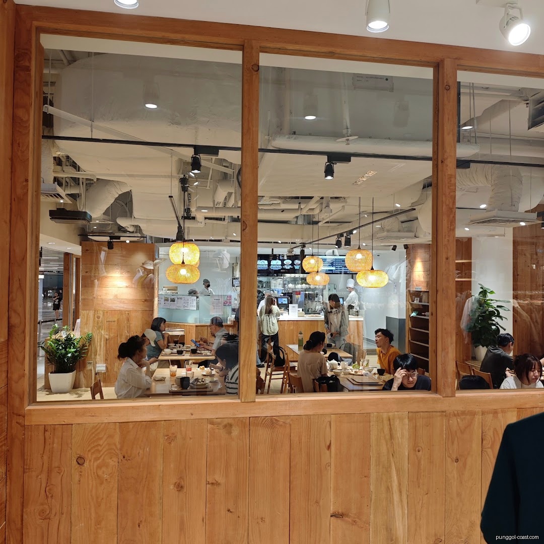 People dining inside a restaurant, viewed through a large window.