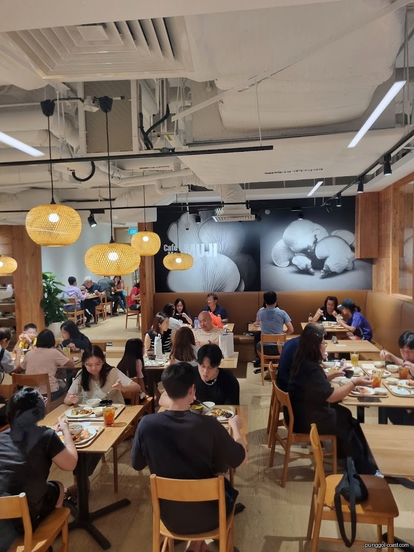 People dining inside a busy Cafe MUJI restaurant.