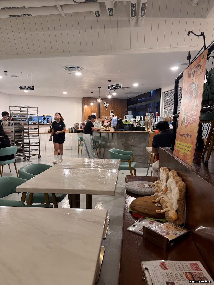 Interior view of a cafe with tables, counter, and people.