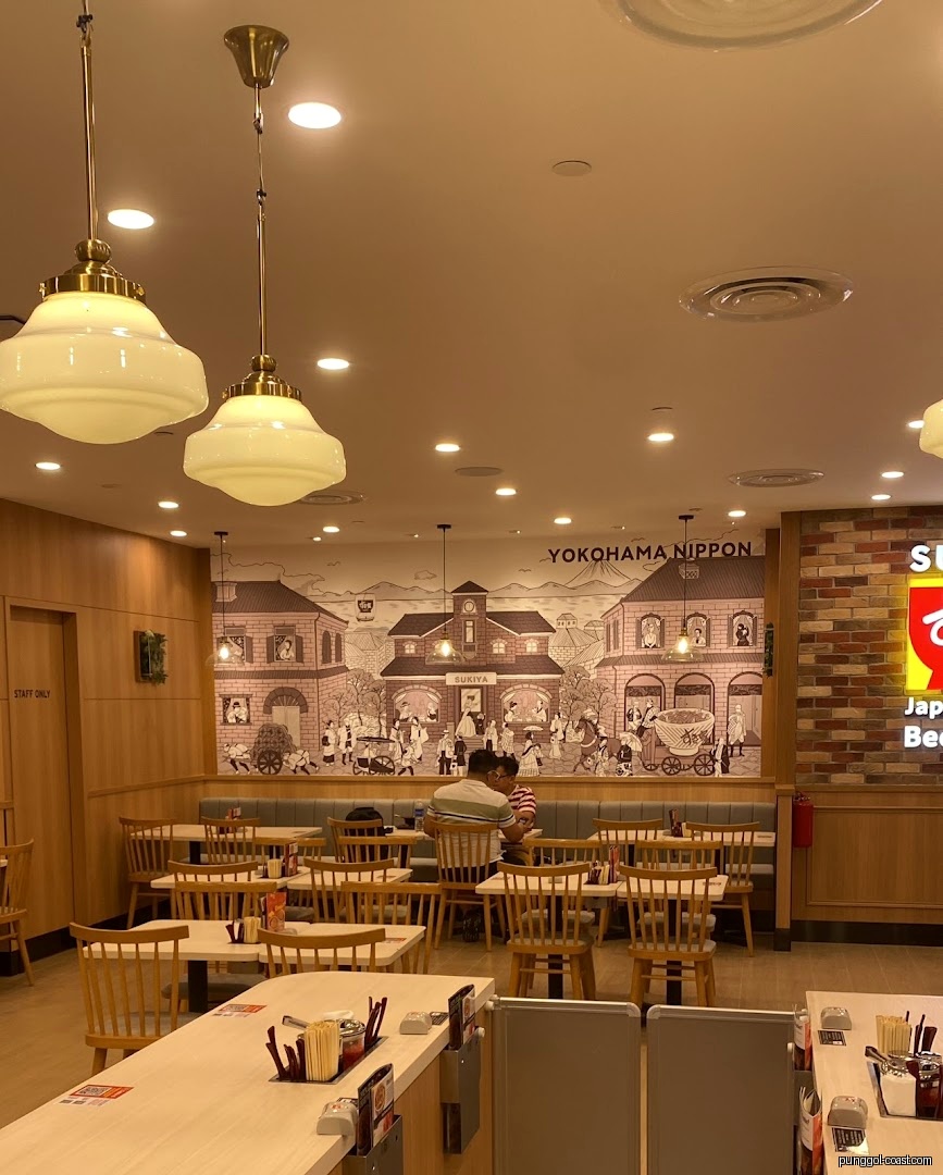 Restaurant interior with dining tables, chairs, and a large wall mural.