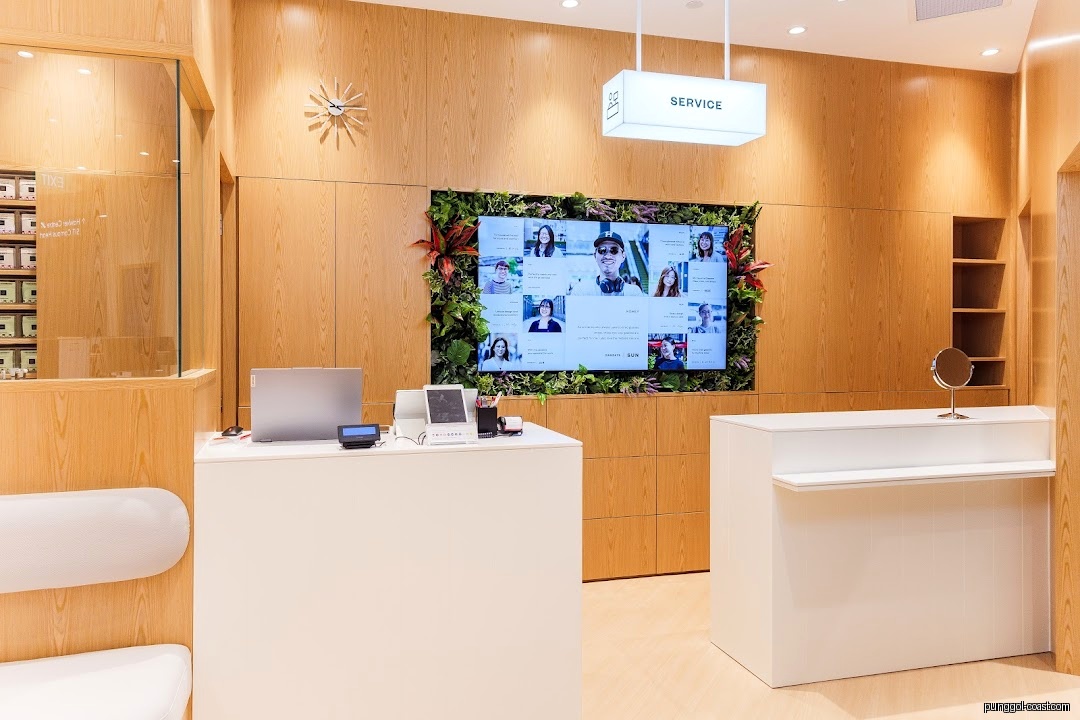 Shop interior with service counter, large screen, and wooden paneling.