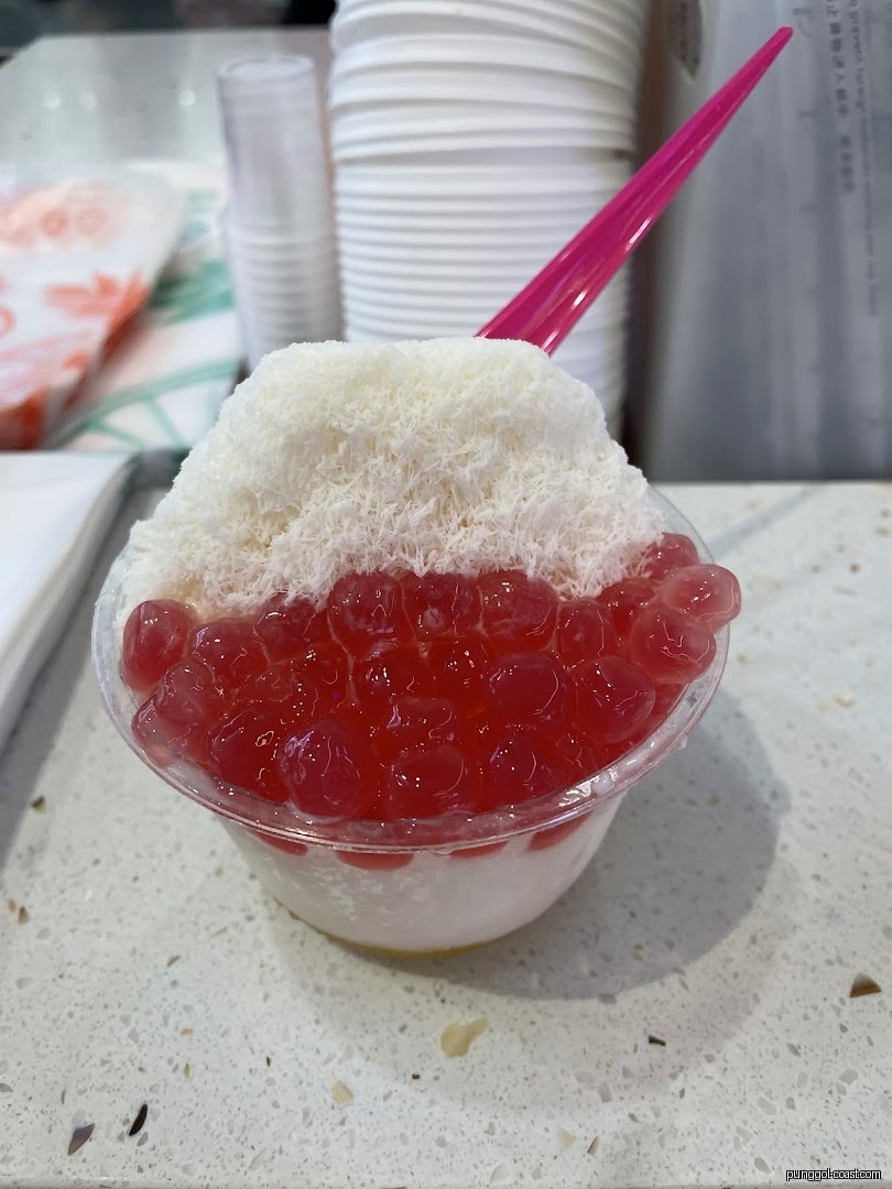 Close-up of a dessert cup with shaved ice and red boba.