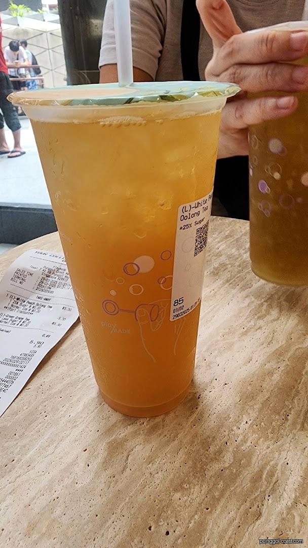 Two large drinks and a receipt on a table from PlayMade.