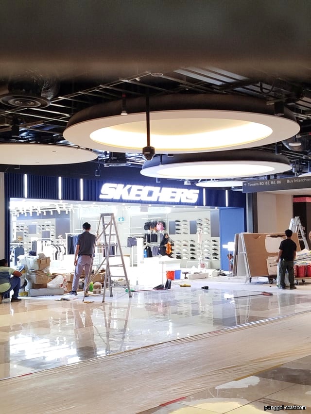 Skechers shop front with workers and equipment, possibly under setup.