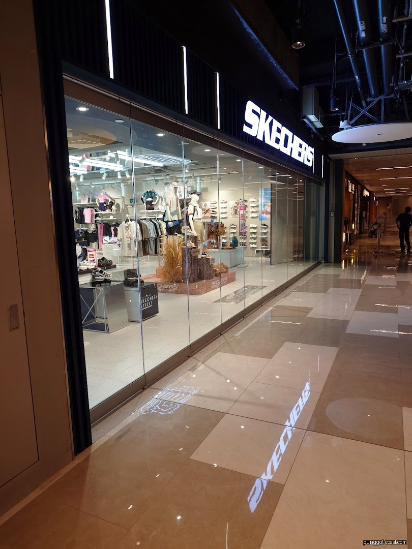 Skechers store exterior in a mall, showing products through glass.