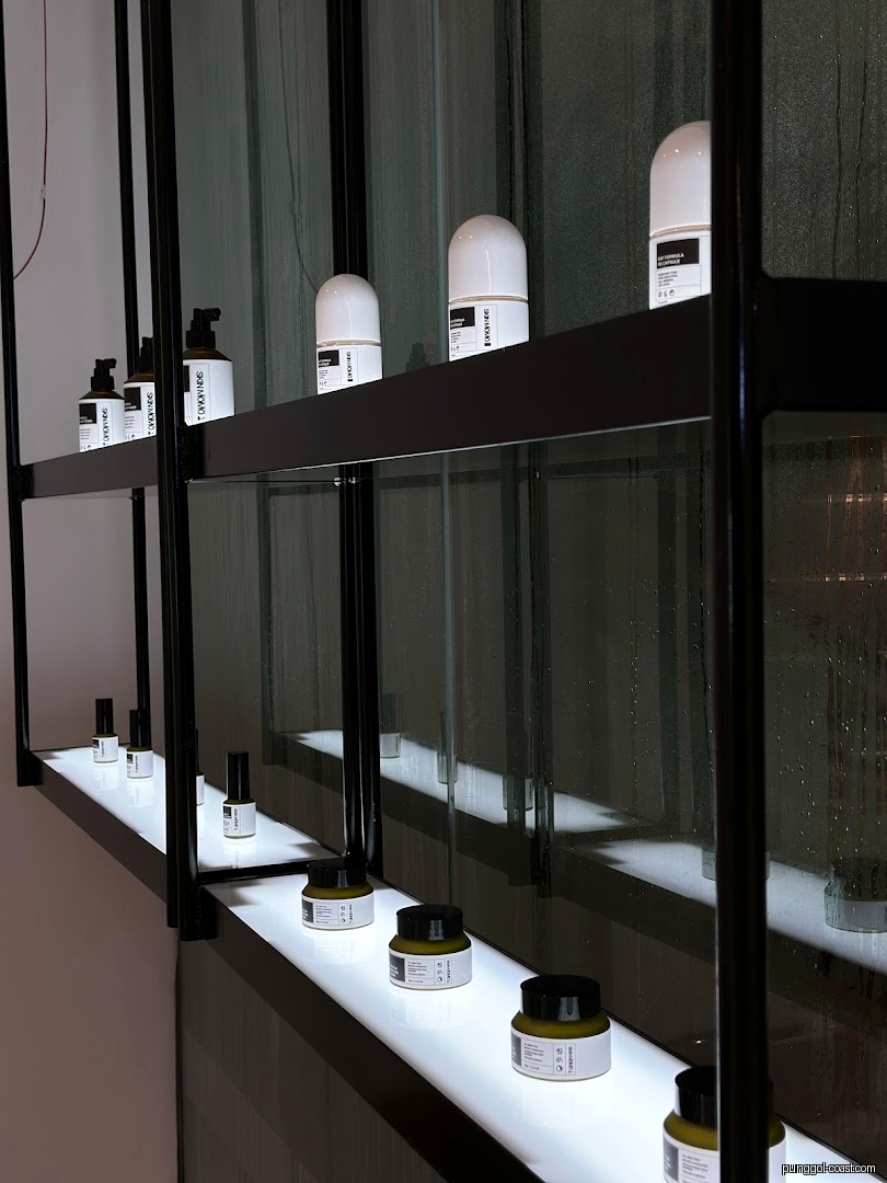 Cosmetic products displayed on illuminated shelves inside a shop.