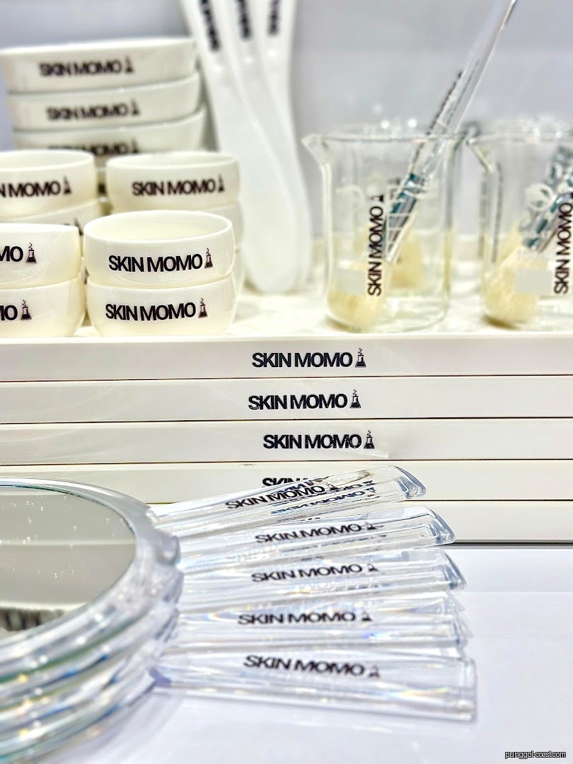 Various SKIN MOMO branded skincare tools and accessories are displayed.
