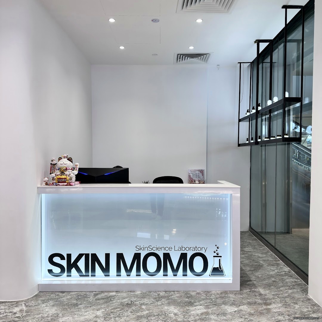 Interior view of SKIN MOMO reception desk with branding and product display.