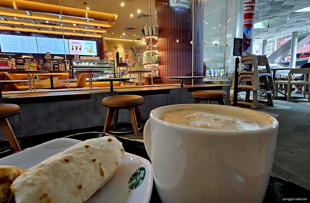 Customer's view inside Starbucks, showing coffee, food, counter, and seating.