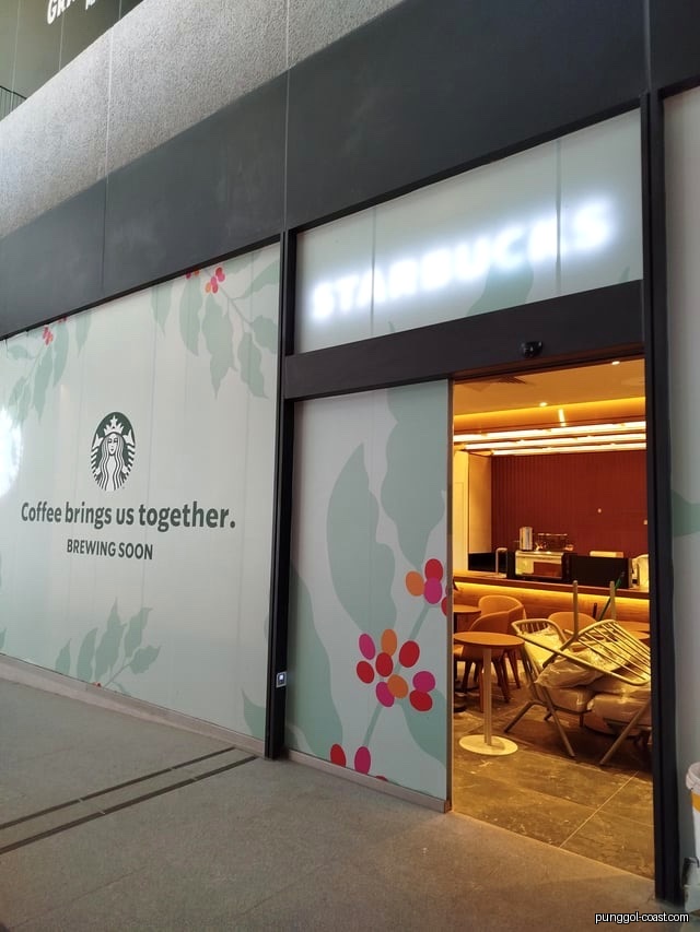 Starbucks shop exterior with 'Brewing Soon' banner, showing interior.