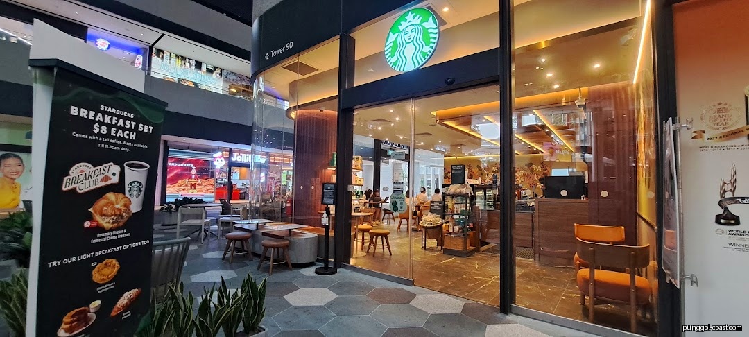 Starbucks shop front with entrance, outdoor seating, and a promotional banner.