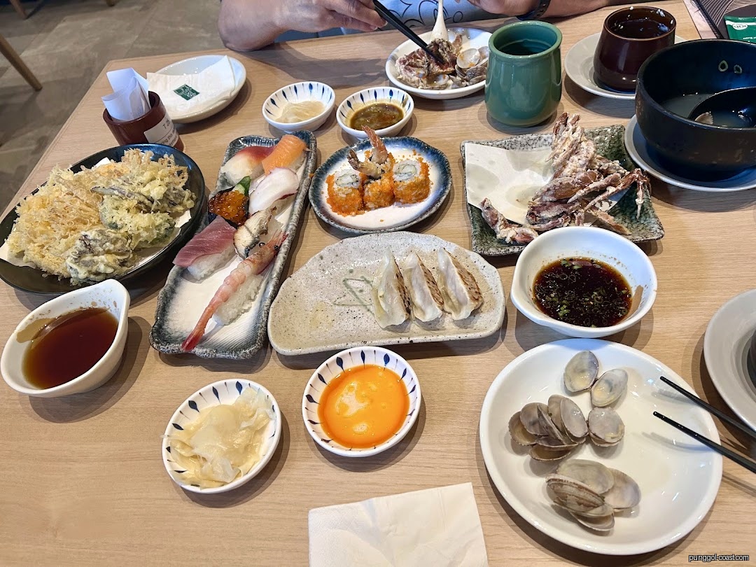 A table filled with various Japanese dishes, including sushi and tempura.