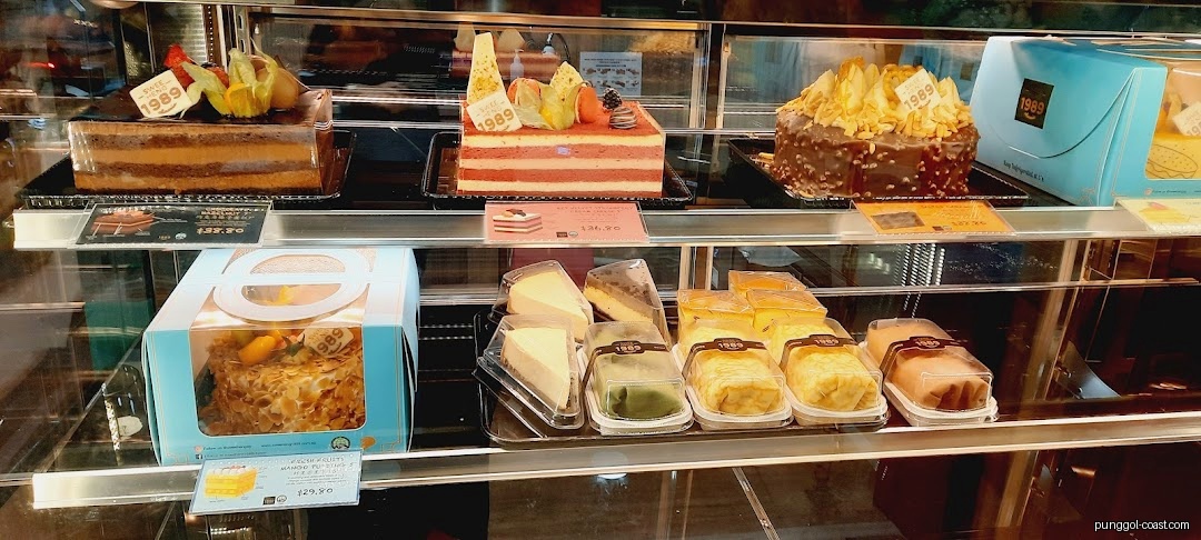 Various cakes and pastries displayed in a glass counter.