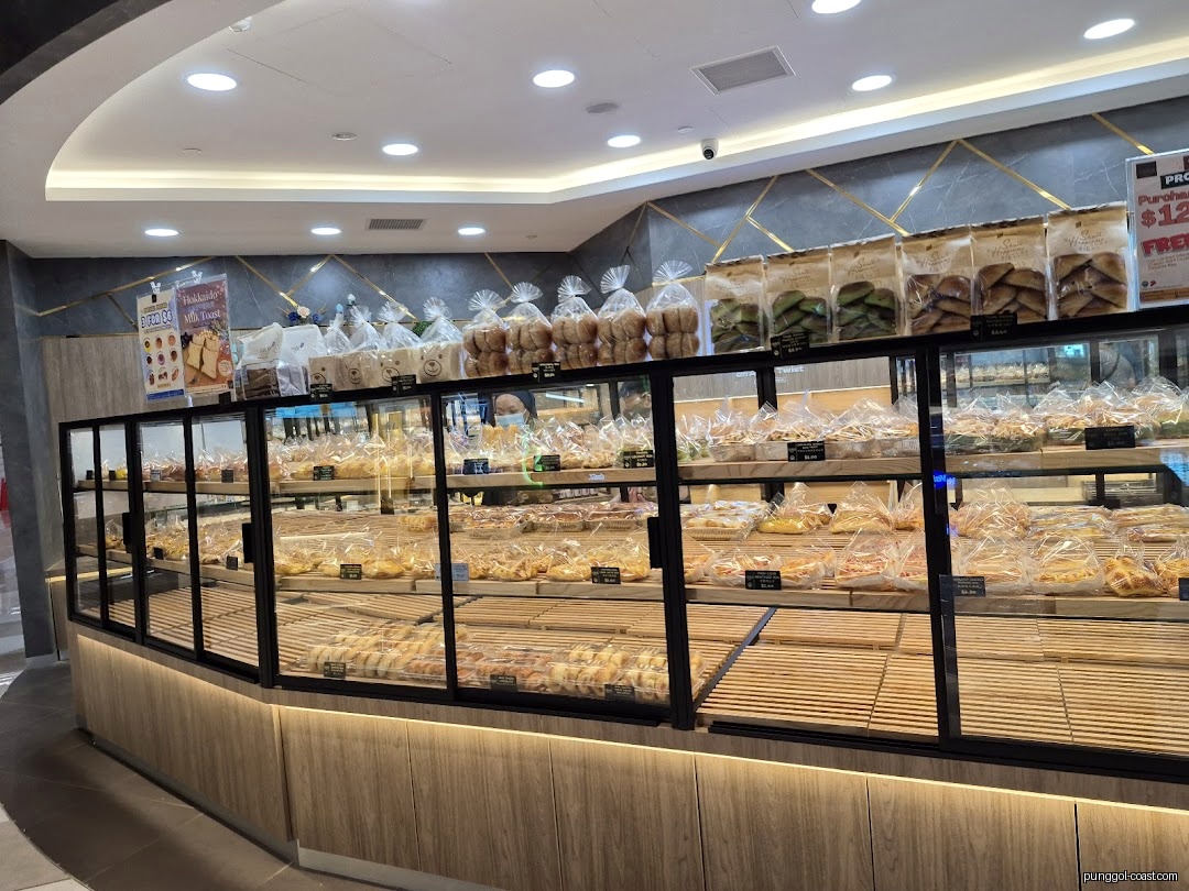 Interior view of a bakery with display cases full of bread and pastries.